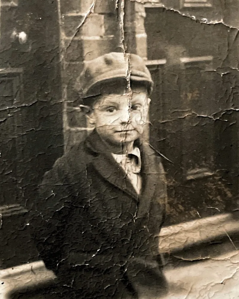 A young boy in a cap, before restoration: the print is cracked and flaking
